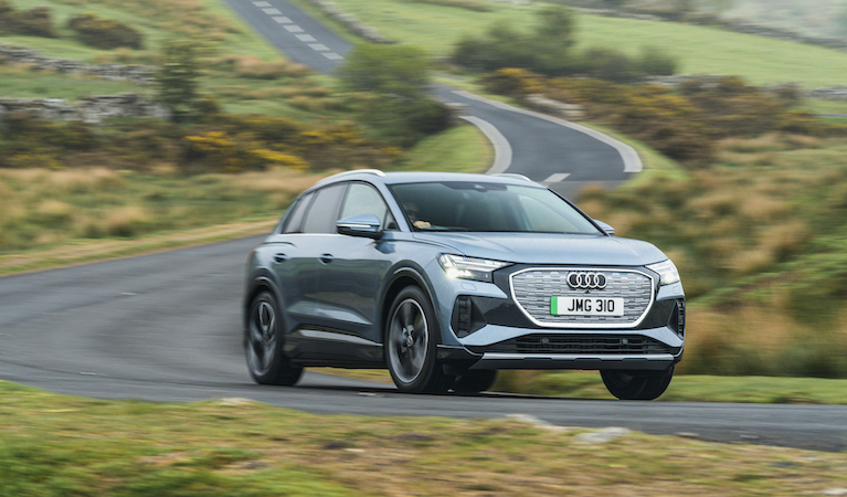 Audi Q4 e-tron front action shot, straight road in countryside, blue/silver car, RHD, UK plates