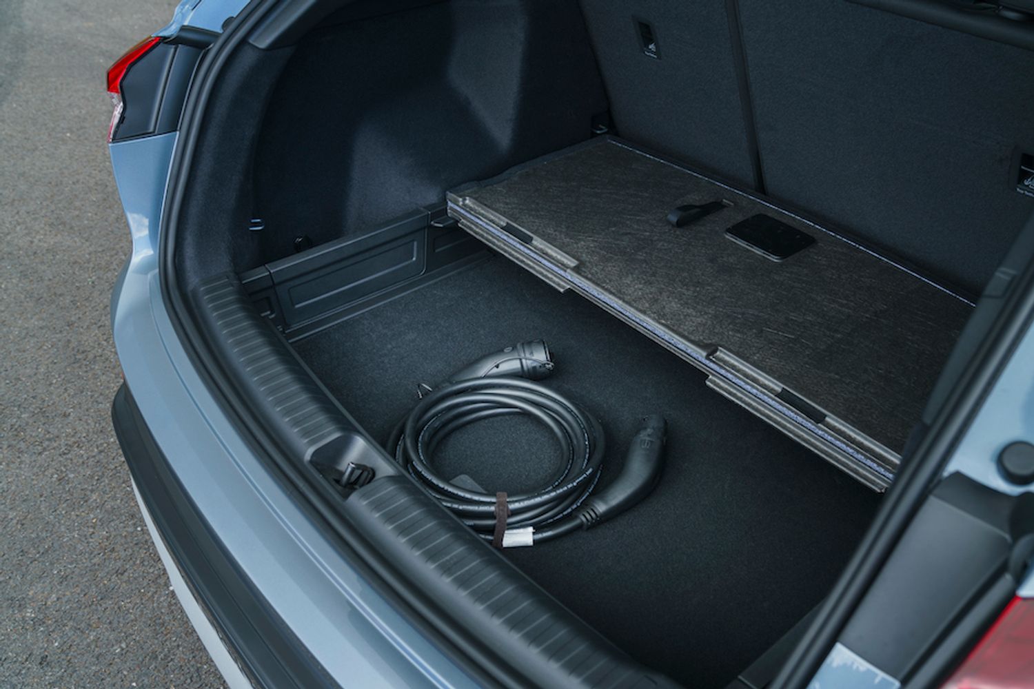 Audi Q4 e-tron boot space showing cable storage under floor, blue/silver car