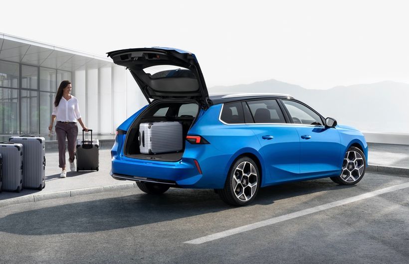 Blue 2022 Vauxhall Astra Sports Tourer rear shot, boot open, luggage and lady