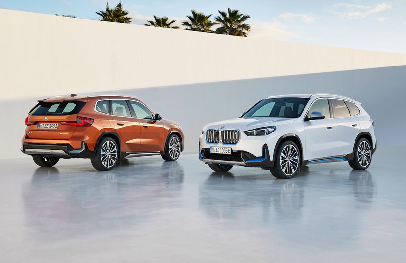 BMW iX1 and X1, German registered, front three quarters white car and rear of orange car
