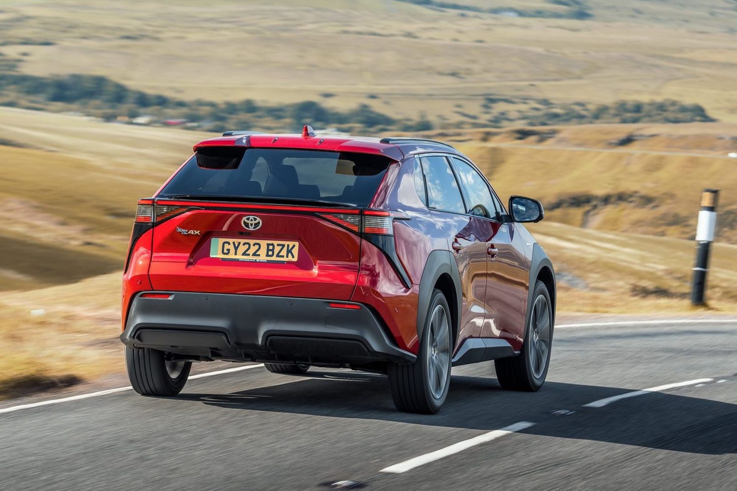 Toyota bZ4x action shot, rear, red car, RHD UK registration