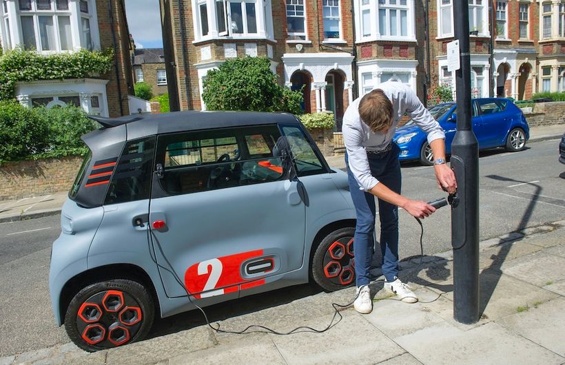 Citroen Ami in UK, being plugged in to ubitricity charge point on a lamp post in street