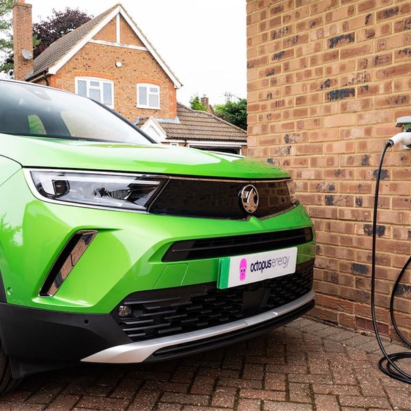 Green Vauxhall Mokka plugged into Ohme charger with Octopus Energy branded numberplate