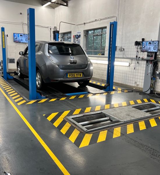 Grey 2015 Nissan Leaf in MoT test bay on ramps