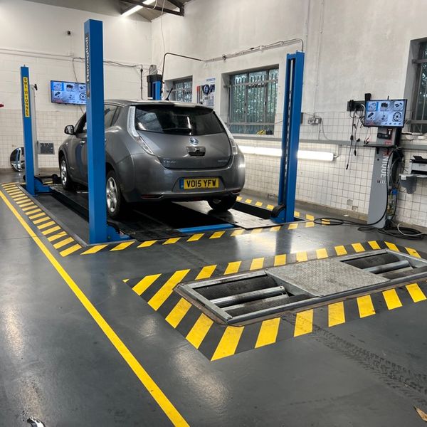 Grey 2015 Nissan Leaf in MoT test bay on ramps