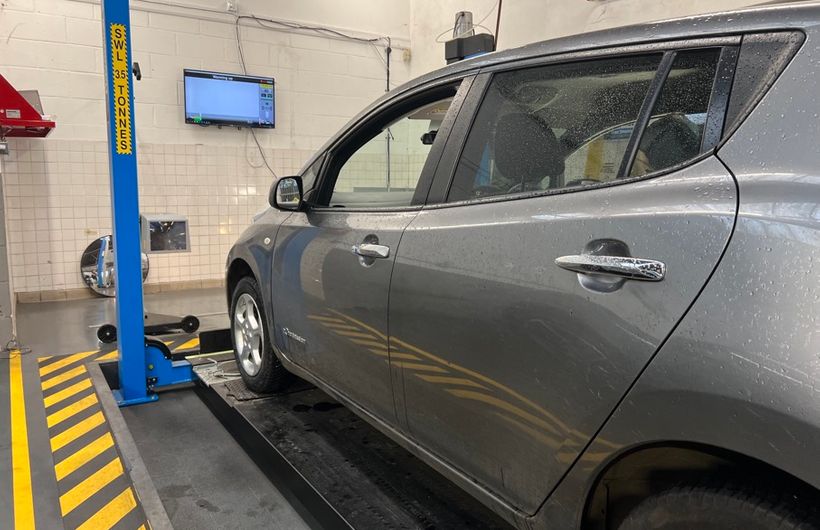 Grey 2015 Nissan Leaf in MoT test bay on ramps