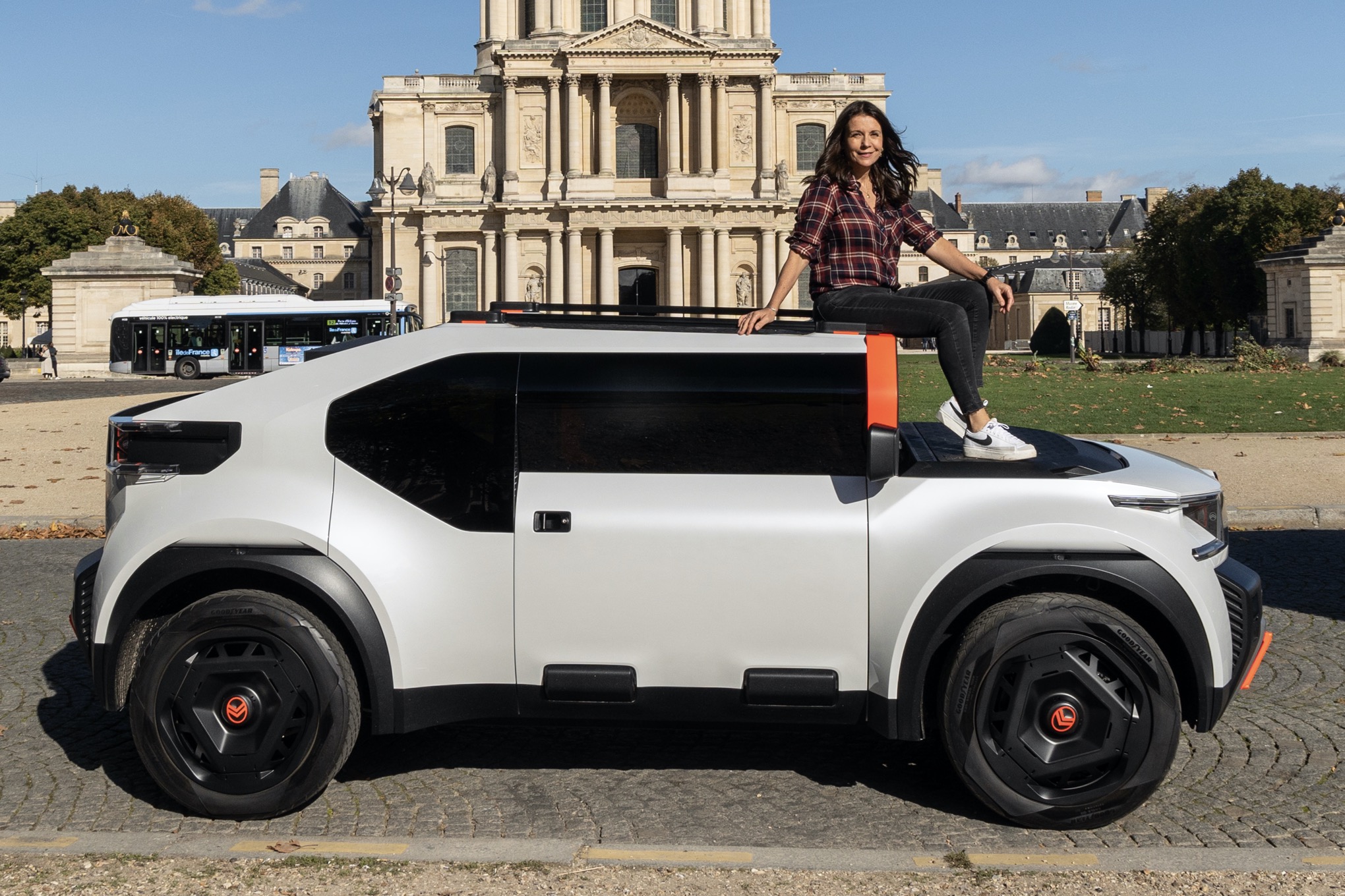 Ginny Buckley sitting on roof of Citroen Oli concept in Paris, side on