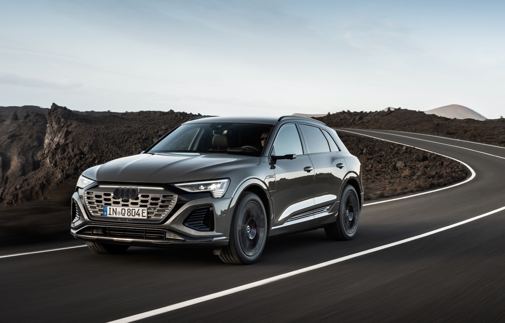 Audi Q8 e-tron front tracking action shot, green car,  left hand drive car